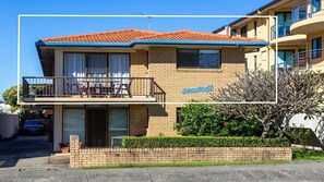 A two-story building with a balcony, a sign reading 'Seadrift,' and a brick wall in front.