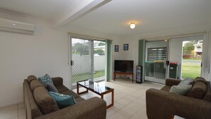 Relax in this stylish living room with a flat-screen TV, comfortable sofas, and a glass coffee table.
