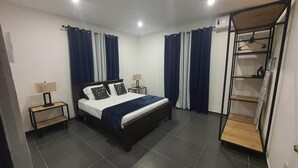 A modern bedroom with a large bed, two bedside tables, a wardrobe, and a ceiling light. - Duzu Nature View Curacao (Tera Kora)