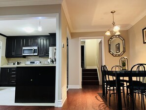 Enjoy meals in the kitchen with a microwave and coffee maker, and dine in the adjacent dining area with a round table and black chairs.