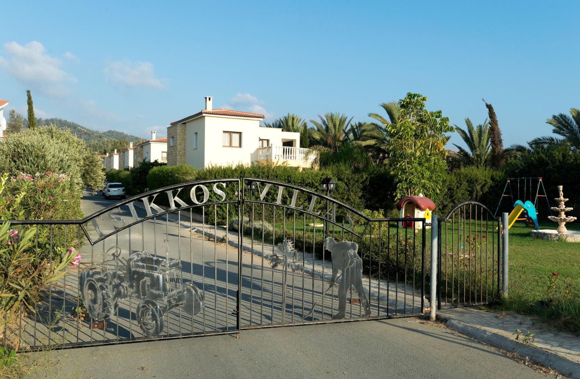 A gated entrance with a metal gate displaying the name "KOS VILLAS".