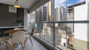 A modern dining area with a large window, a dining table, chairs, and a pendant light. - Vi0405 Vision Augusta (São Paulo)