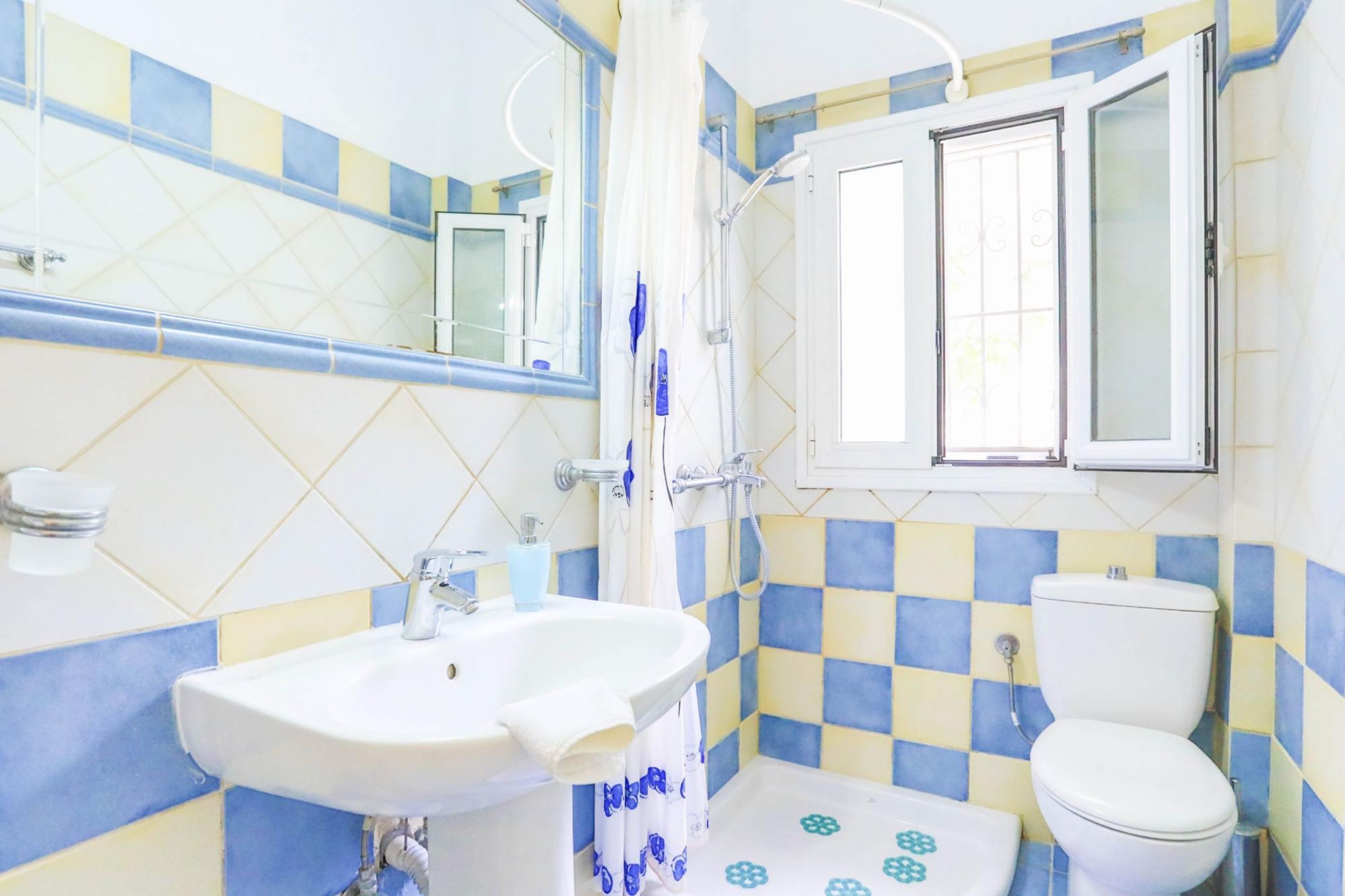 A bathroom with a sink, toilet, and shower.