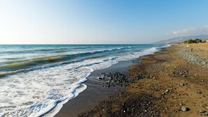 Ein Strand mit felsigem Ufer und Wellen.