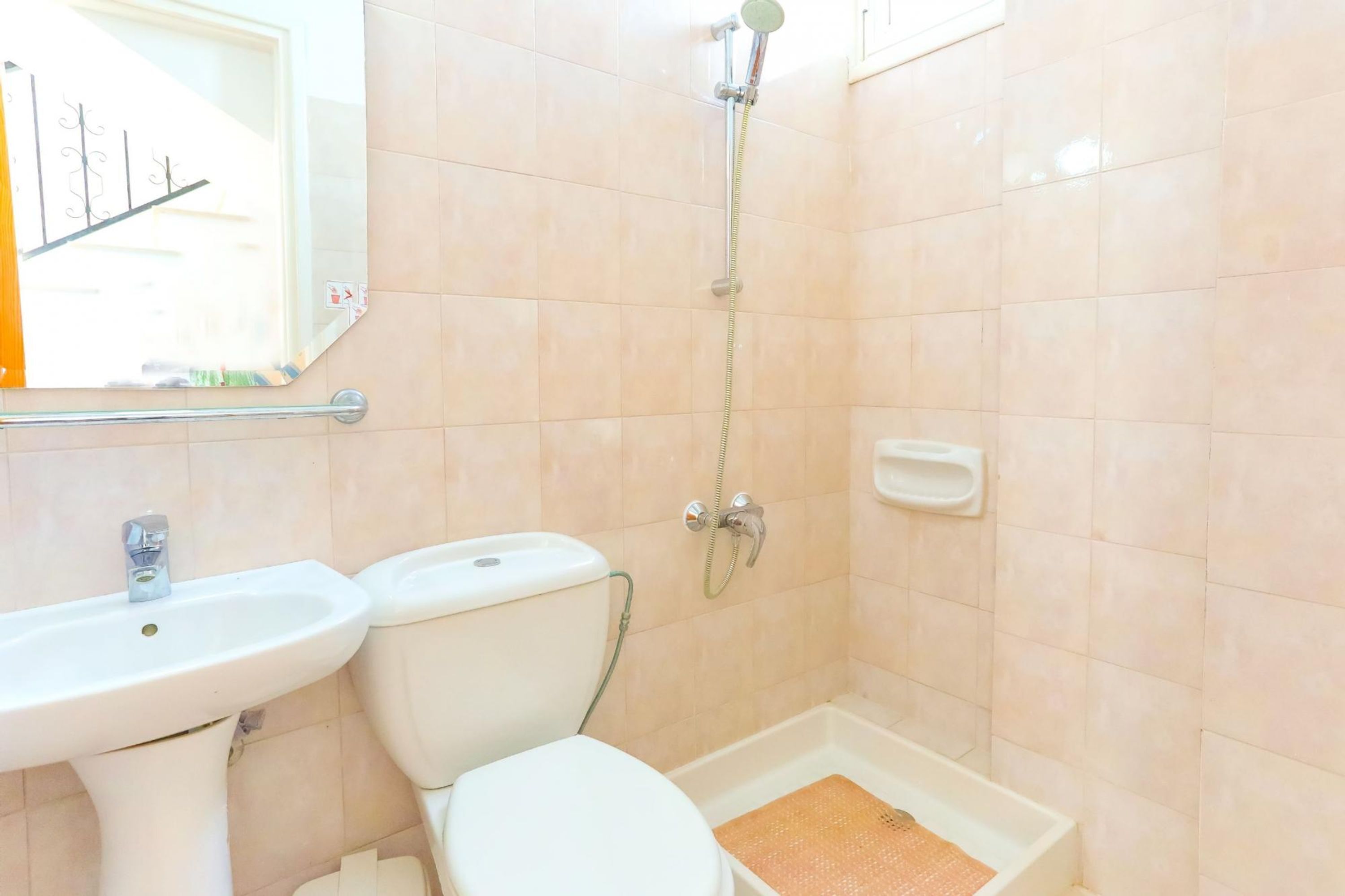 A bathroom with a sink, toilet, and shower.