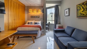 A modern hotel room with a bed, a sofa, a desk, and a dining area. - Br156166 Sirio Libanes (São Paulo)