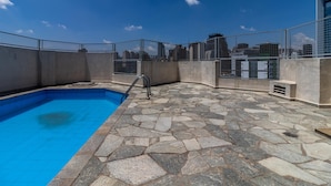 A rooftop swimming pool with stone flooring and a metal safety fence. - Br156166 Sirio Libanes (São Paulo)