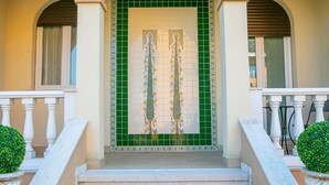 A building entrance with a green tiled door, white balustrades, and a staircase leading up to the entrance. - Villa Mimosa - Appartamento 2 (Desenzano del Garda)
