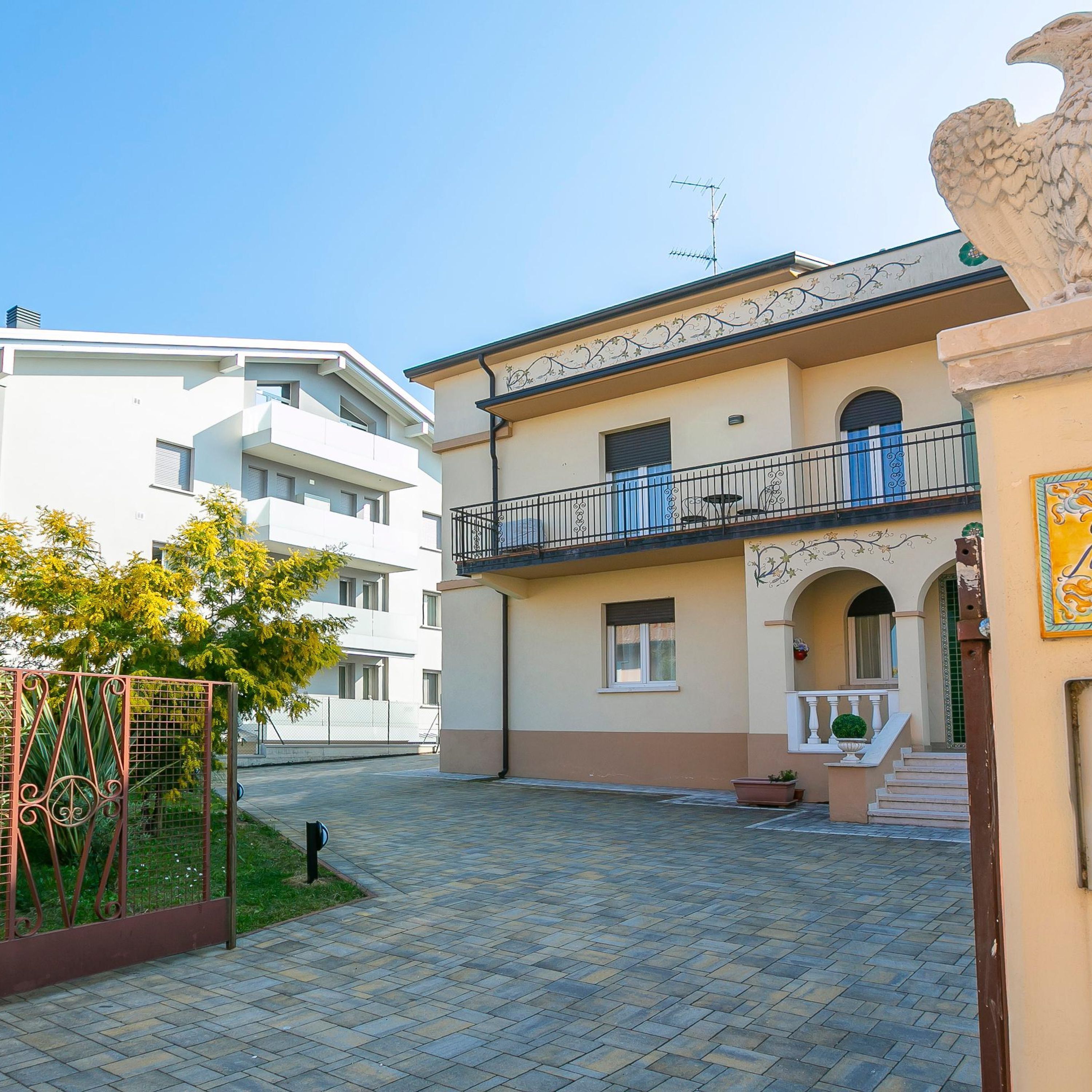 A courtyard with a building featuring a balcony and a small garden area.