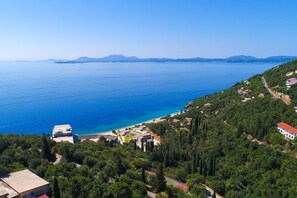 A coastal area with a beach, buildings, and a road. - Vista Mare Assinia in Kentroma (Corfu)