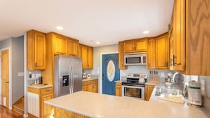 Una cocina moderna con armarios de madera, electrodomésticos de acero inoxidable y una isla grande.