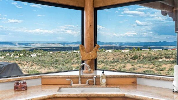 A kitchen with a large window, a wooden cabinet, and a sink. - Stunning Views, Pool, Sauna, Steam Shower, Firepit! (Cottonwood)