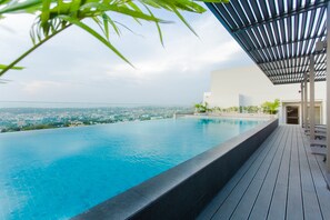 A rooftop infinity pool with a city view, wooden deck, and a covered seating area. - Accra Luxury Apartments at The Lennox (Accra)