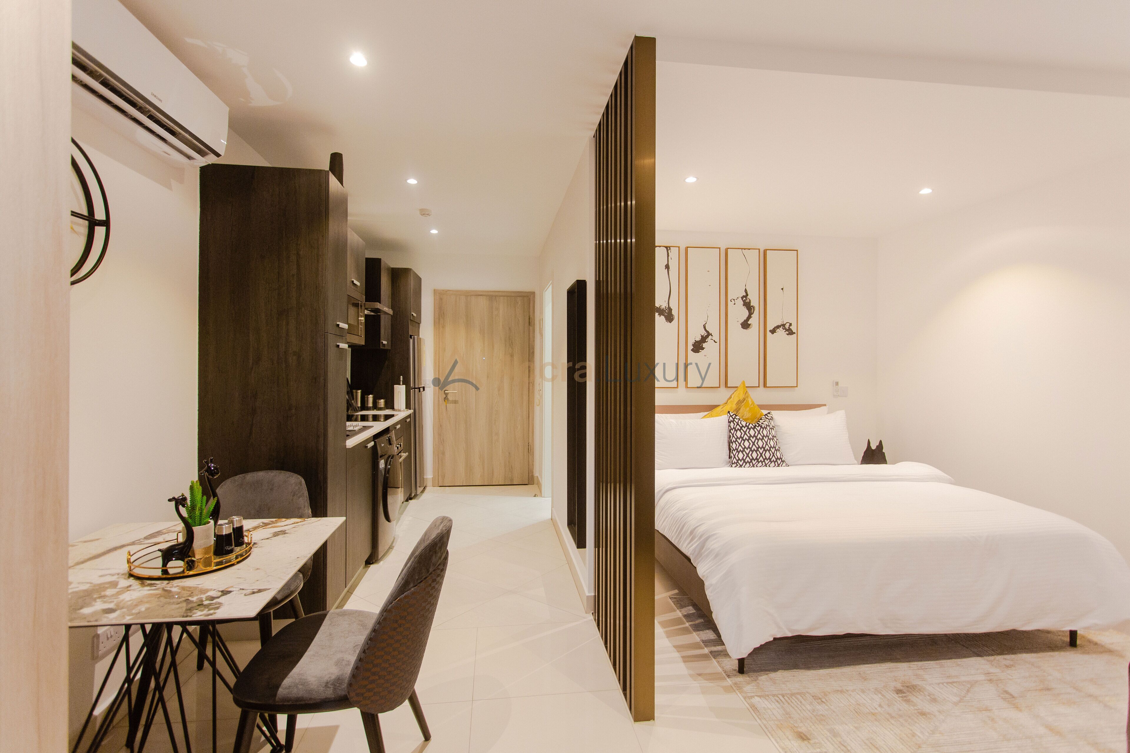 Ein modernes Hotelzimmer mit einem großen Bett, einem Schreibtisch mit Stuhl und einer kleinen Essecke.
