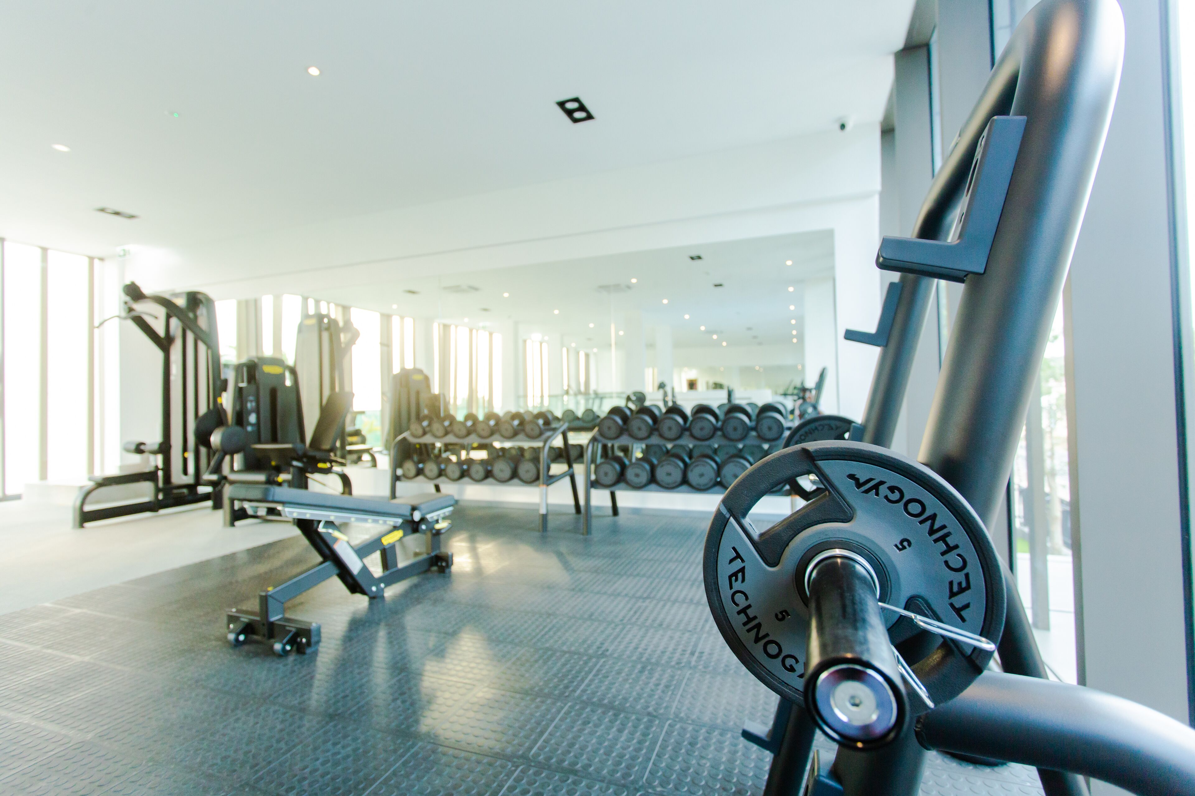 Een sportschool met diverse fitnessapparaten, waaronder gewichten en krachtapparaten.