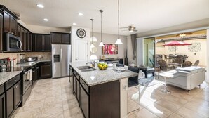 A modern kitchen with dark cabinets, stainless steel appliances, and a granite island. - "Sweet Retreat" - Free Pool Heat & Bbq (Kissimmee)