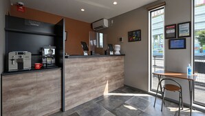 A modern coffee shop interior with a counter, espresso machine, and seating area. - HOTEL R9 The Yard Shikokuchuo (Shikokuchuo)