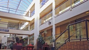 A multi-level atrium with glass railings, indoor plants, and a staircase. - Christie Lodge Avon Vail for New Years (Avon)