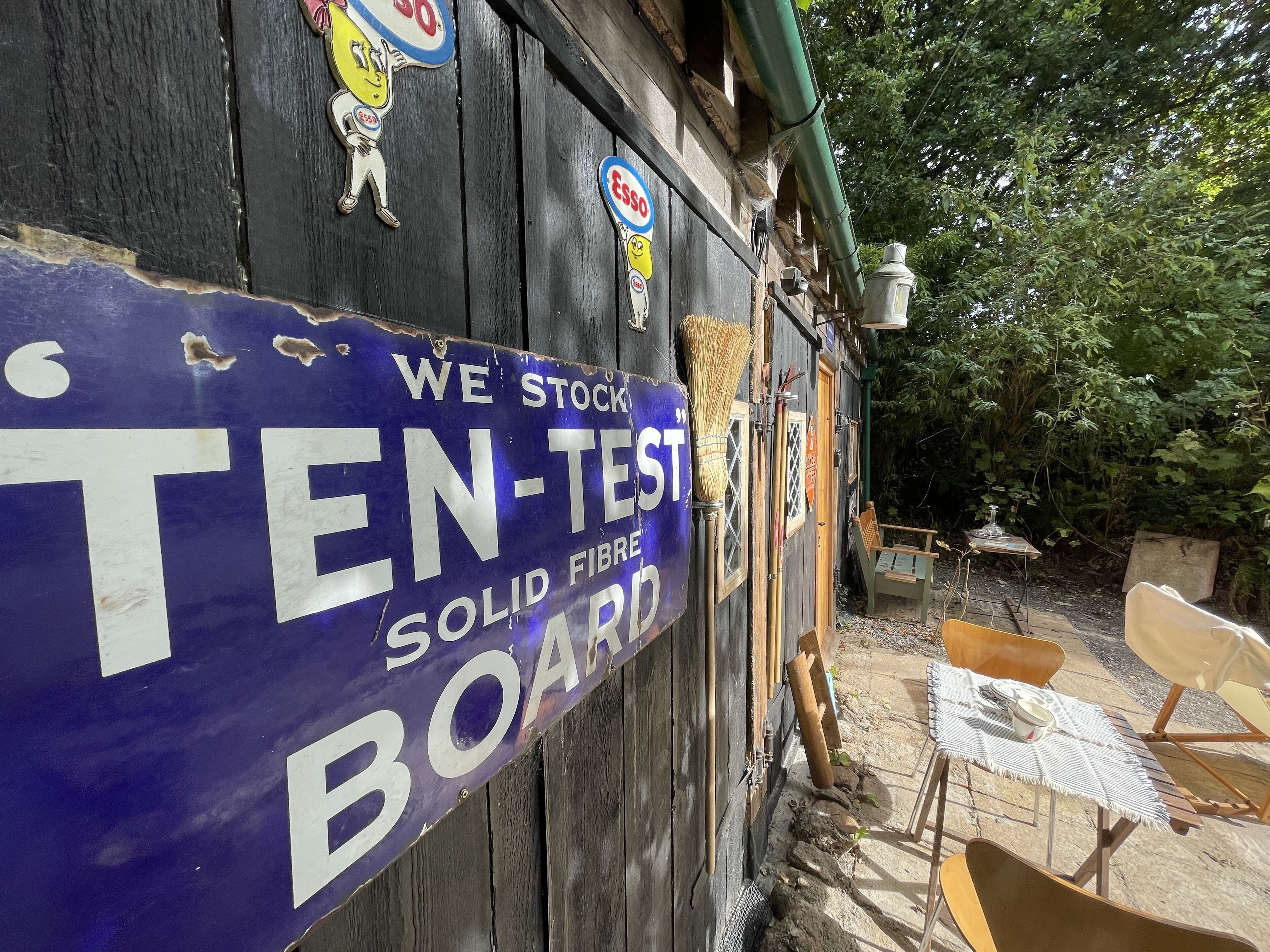 Un bâtiment en bois sur lequel est apposée une enseigne publicitaire pour des « panneaux de fibres solides testés à dix reprises ».