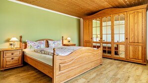 A wooden bed with a headboard, nightstands, and a wooden wardrobe with glass doors. - Apartment "Oberberg" with Garden & Wi-Fi (Oberreute)