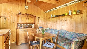 A wooden interior with a dining table, chairs, a sofa, and a cabinet. - Apartment "Oberberg" with Garden & Wi-Fi (Oberreute)