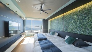 A modern bedroom with a large bed, a ceiling fan, a TV, and a balcony with a view. - GLAMPREMIER Setouchi (Kanonji)