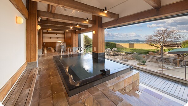 A spa area with a hot tub, wooden beams, and a view of the landscape. - GLAMPREMIER Setouchi (Kanonji)