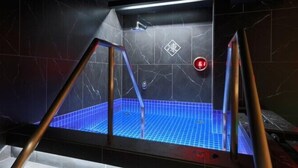 A modern bathroom with a blue-tiled shower area, a handrail, and a red emergency light. - Rembrandt Cabin and Spa Shimbashi - Caters to Men (Tokyo)