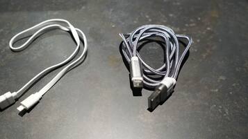 Kaksi USB-kaapelia tummalla alustalla.