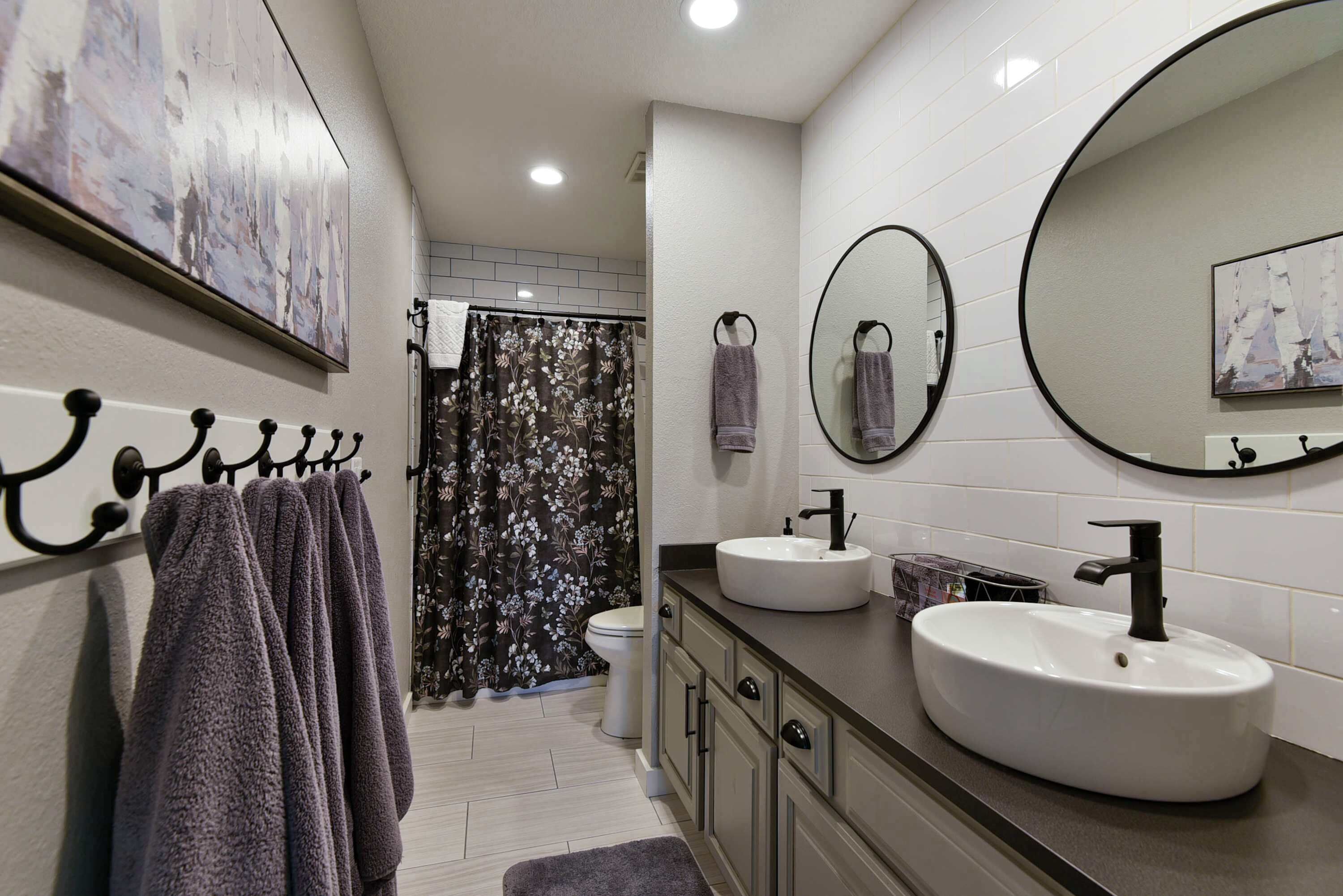 Un bagno moderno con uno specchio grande, due lavabi e una zona doccia.