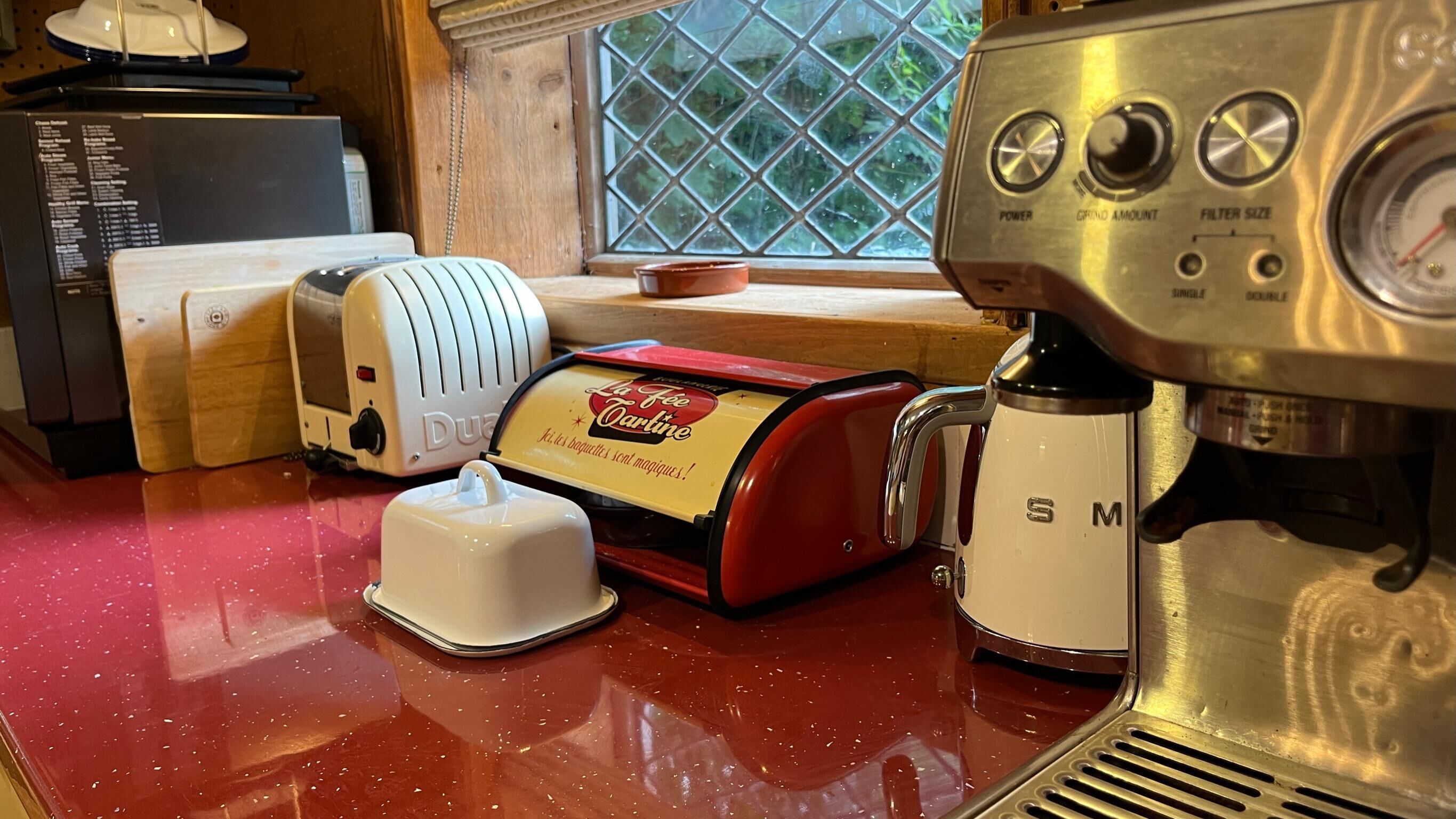 A kitchen with a vintage coffee maker, a toaster, and a red appliance on a red countertop.