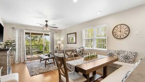 A dining area with a wooden table, chairs, and a ceiling fan. There is a window with a view of greenery outside. - Valley View Treehouse - Holiday Hills Branson Golf Resort Outdoor Pools (Branson)