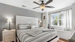 A bedroom with a bed, nightstands, a ceiling fan, and a window with curtains. - Valley View Treehouse - Holiday Hills Branson Golf Resort Outdoor Pools (Branson)