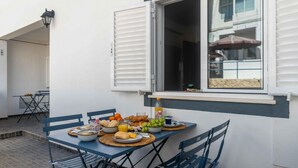 A dining area with a table set for breakfast, including croissants, fruits, and juice. - Casa Almar by Portucasa (Lagoa)