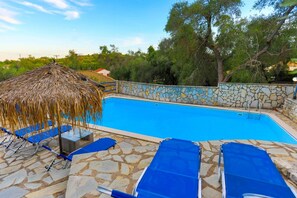 A swimming pool with stone walls and blue lounge chairs. - Villa Alkinoos Secluded Private Pool Wifi A C (Paxos)
