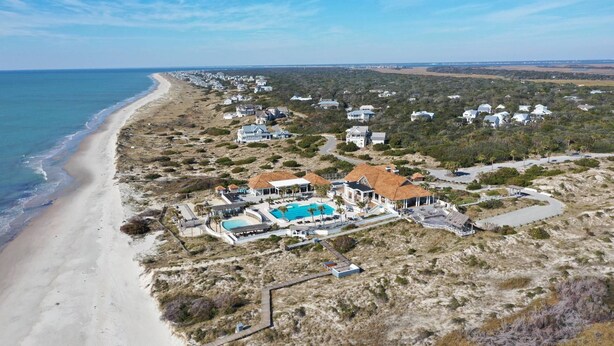 An aerial view of a coastal property with a swimming pool, beach access, and multiple houses. - Chic + Modern BHI Retreat, Both Clubs, 3 Golf Carts, 5 Porches w/Great Views (Bald Head Island)