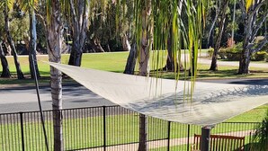 A swimming pool with a surrounding fence, a bench, and lounge chairs. - Barham Bridge Motor Inn (Barham)