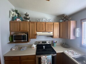 Enjoy cooking in this kitchen with a stove, microwave, and sink.