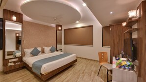 Una habitación de hotel moderna con una cama, un escritorio, una silla y un espejo.