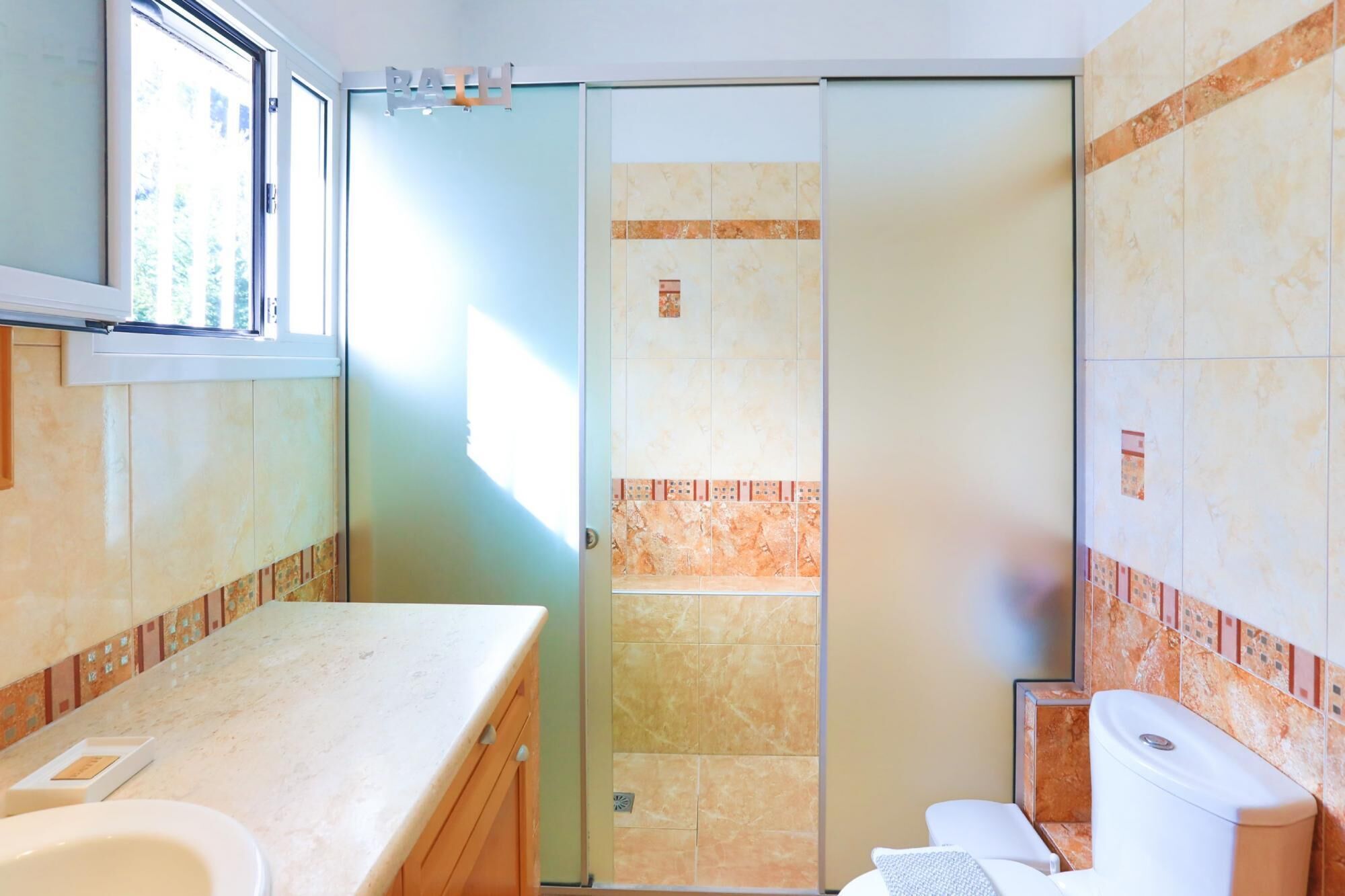 A bathroom with a shower, toilet, and sink.