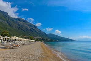 Relax on the beach with comfortable sun loungers and umbrellas.