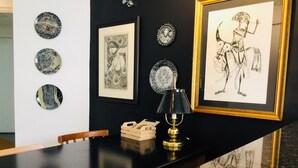 A dining area with a black marble table, framed artwork on the wall, and a decorative lamp. - Ofp1312 Duplex Oscar Freire (São Paulo)