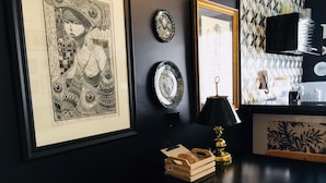 A room with a black table, a framed artwork, a mirror, and a patterned wall. - Ofp1312 Duplex Oscar Freire (São Paulo)