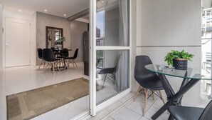 Eine moderne Wohnung mit Essbereich, einem Glastisch und einer Zimmerpflanze.
