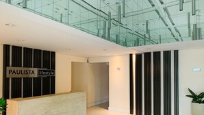 Un espace d’accueil moderne avec un comptoir de réception portant l’inscription « PAULISTA lifestyle ».