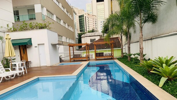 Une piscine avec des chaises longues et une terrasse en bois.