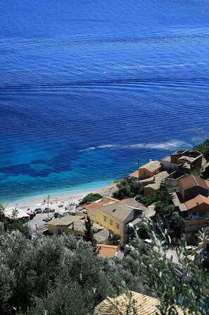 A coastal town with buildings near the beach and clear blue waters.