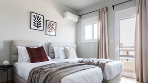 Un dormitorio moderno con cama, dos mesitas de noche, una ventana y un balcón.
