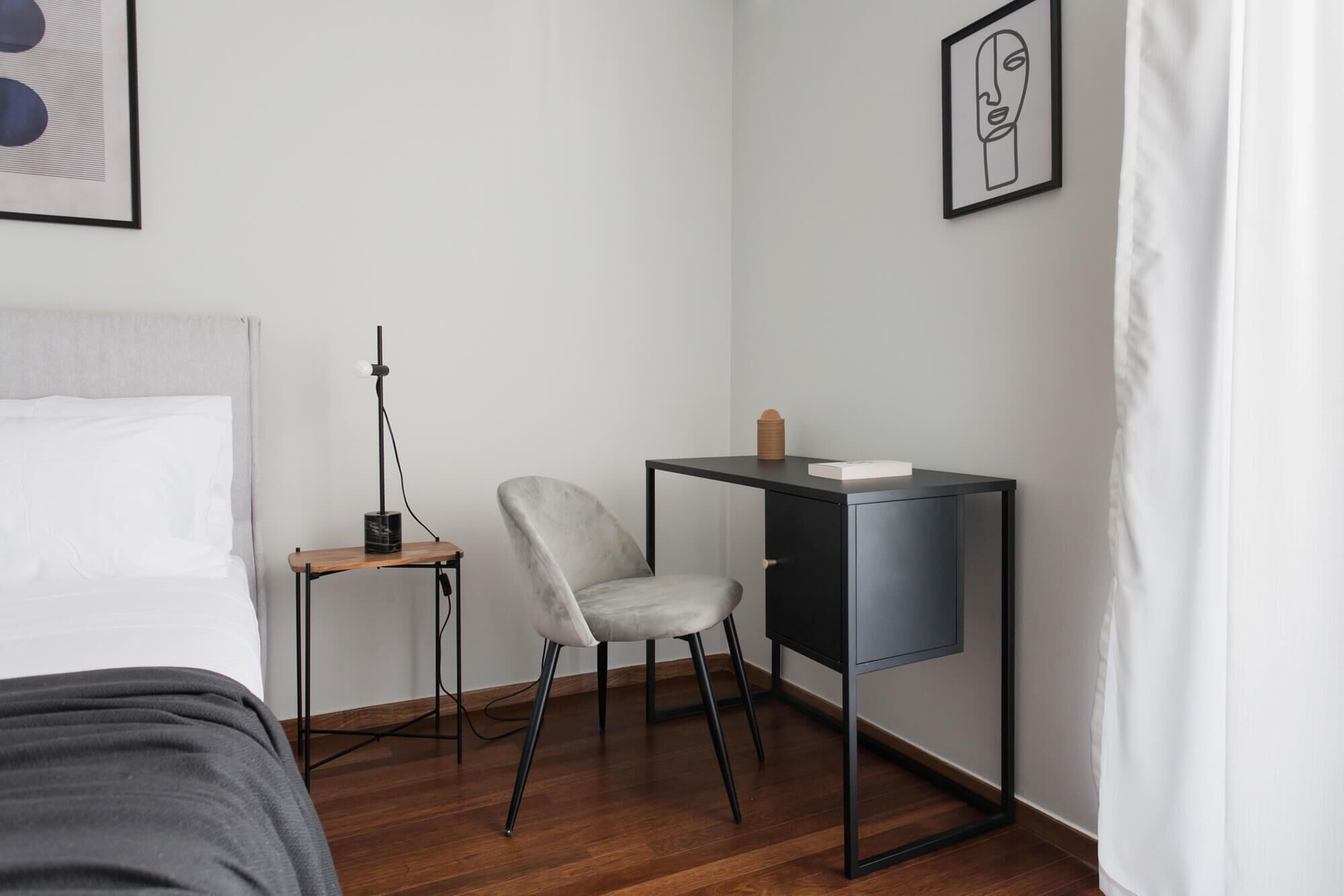 A minimalist bedroom with a bed, a desk, and a chair.