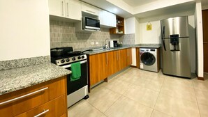Eine moderne Küche mit Herd, Backofen, Mikrowelle, Waschmaschine und Kühlschrank.